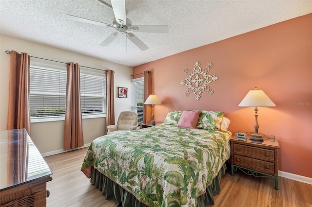 7193 W Country Club Dr N Unit 137, Sarasota, FL 34243 - bedroom with a textured ceiling, light wood-style flooring, baseboards, and a ceiling fan