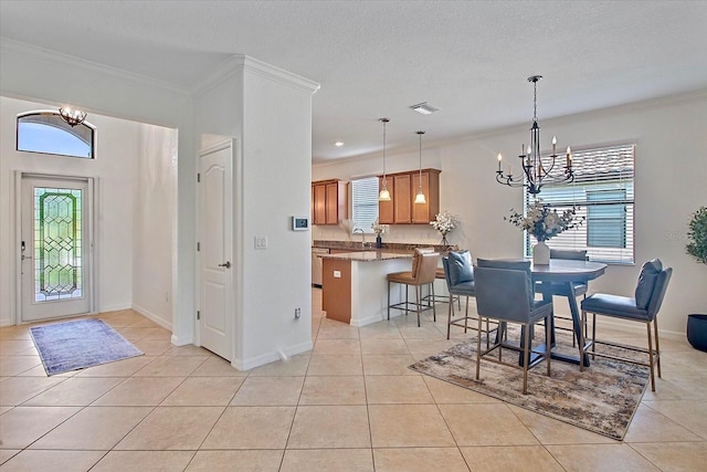 foyer featuring a chandelier, light tile patterned flooring, crown molding, and a textured ceiling