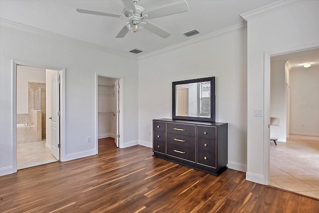 unfurnished bedroom with ornamental molding, dark wood-style flooring, a spacious closet, baseboards, and a closet