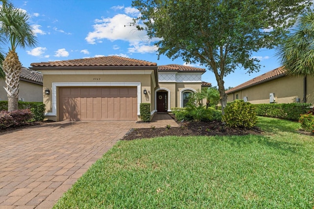 9769 Highland Park Pl, Palmetto, FL 34221 - mediterranean / spanish house with a garage, decorative driveway, a tile roof, a front yard, and stucco siding