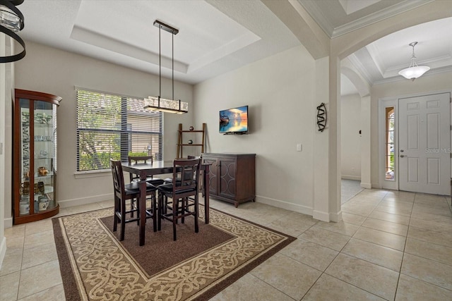 9769 Highland Park Pl, Palmetto, FL 34221 - dining space featuring a tray ceiling, baseboards, arched walkways, ornamental molding, and a chandelier