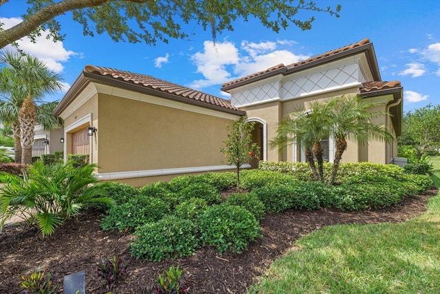 9769 Highland Park Pl, Palmetto, FL 34221 - view of home's exterior featuring a tile roof, an attached garage, and stucco siding