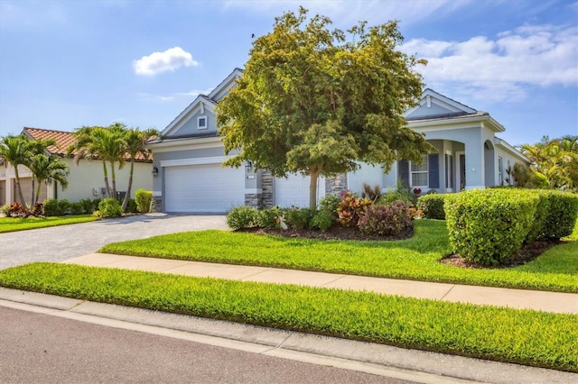 view of property hidden behind natural elements featuring driveway, stucco siding, a front lawn, stone siding, and a garage