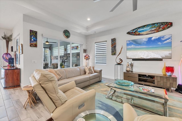 living room with a ceiling fan, baseboards, recessed lighting, a tray ceiling, and crown molding