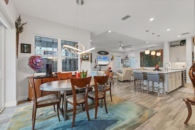 dining area with light wood-style flooring, recessed lighting, baseboards, ceiling fan, and a chandelier