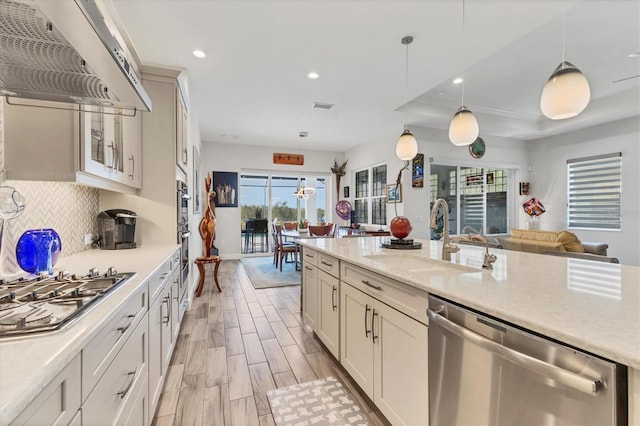 kitchen with appliances with stainless steel finishes, a sink, ventilation hood, recessed lighting, and decorative backsplash