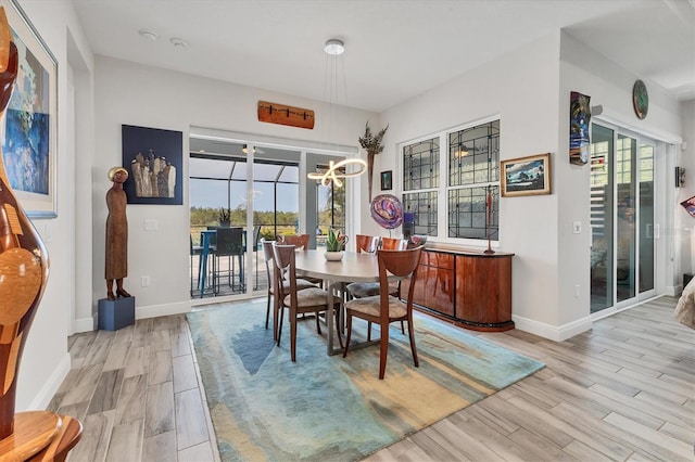 dining space with a chandelier, wood finished floors, and baseboards