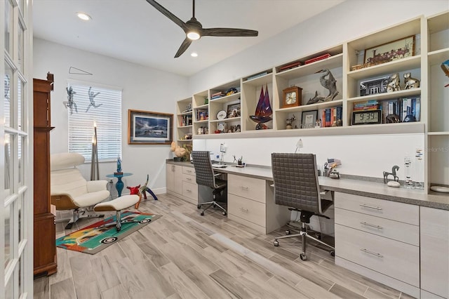 office featuring built in desk, a ceiling fan, light wood-style flooring, and recessed lighting