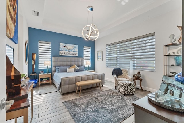 bedroom with wood finished floors, a chandelier, and baseboards