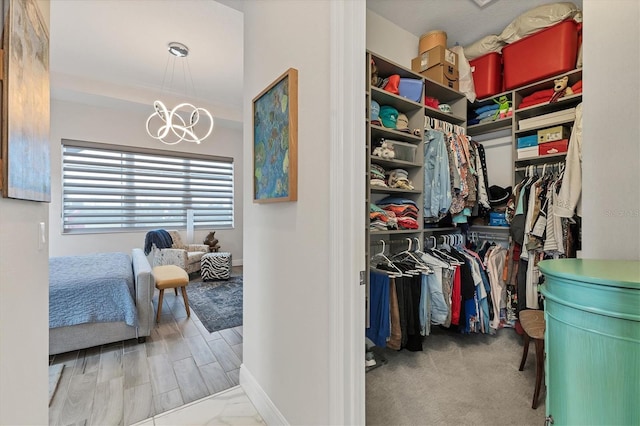 spacious closet featuring a chandelier