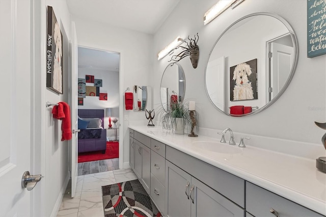 bathroom with marble look tiles, vanity, and baseboards