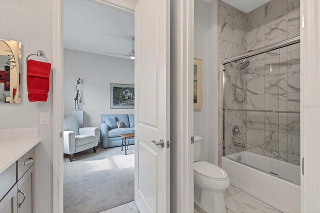 ensuite bathroom featuring marble look tile flooring, vanity, toilet, and bath / shower combo with glass door