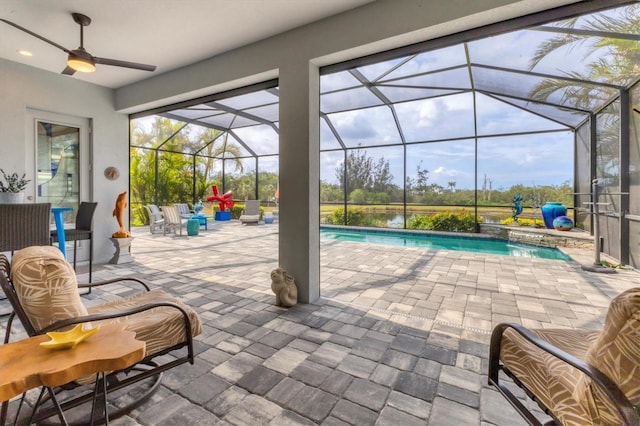 outdoor pool with a patio, ceiling fan, and glass enclosure
