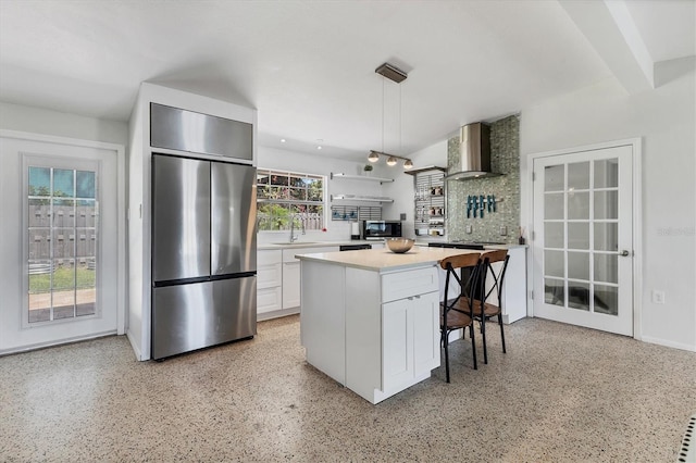 6931 Magellan Way, Sarasota, FL 34243 - kitchen featuring appliances with stainless steel finishes, wall chimney exhaust hood, dark speckled floor, and white cabinets