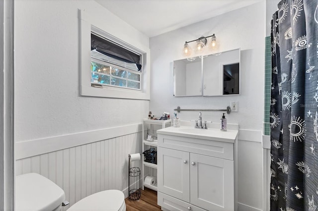 6931 Magellan Way, Sarasota, FL 34243 - bathroom with toilet, wainscoting, wood finished floors, vanity, and a shower with shower curtain