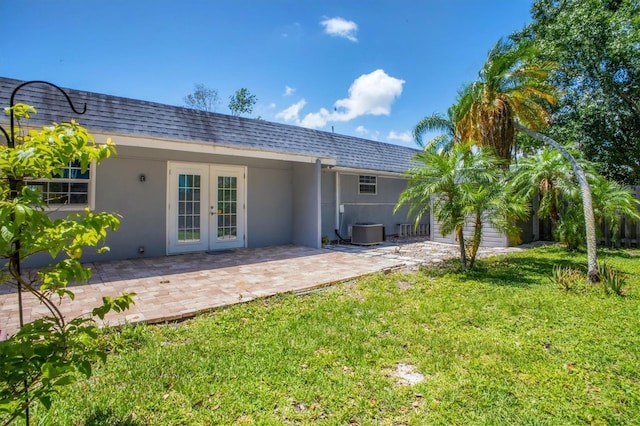 6931 Magellan Way, Sarasota, FL 34243 - back of property featuring french doors, central AC unit, a lawn, stucco siding, and a patio area