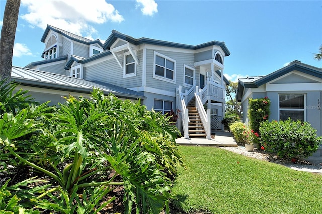 1226 Siesta Bayside Dr Unit 1226C, Sarasota, FL 34242 - view of front facade featuring stairs, a standing seam roof, a front yard, and metal roof