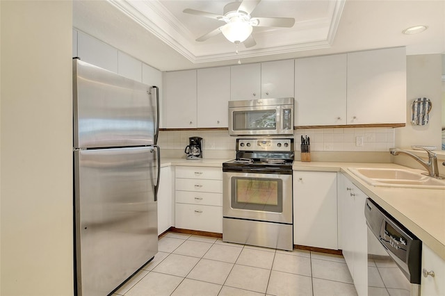1226 Siesta Bayside Dr Unit 1226C, Sarasota, FL 34242 - kitchen with stainless steel appliances, a sink, a tray ceiling, decorative backsplash, and light countertops