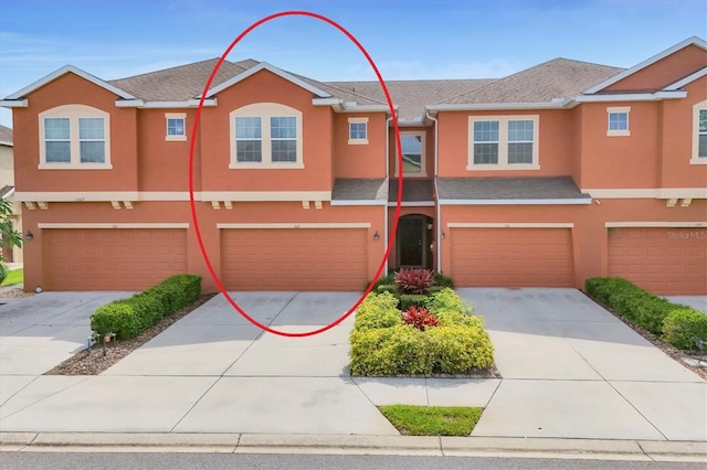11507 84th Street Cir E Unit 102, Parrish, FL 34219 - view of property with stucco siding, an attached garage, and driveway