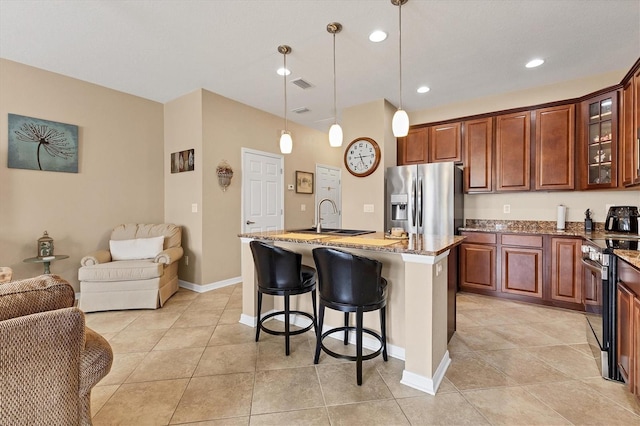 11507 84th Street Cir E Unit 102, Parrish, FL 34219 - kitchen featuring appliances with stainless steel finishes, a sink, open floor plan, stone counters, and a kitchen island with sink