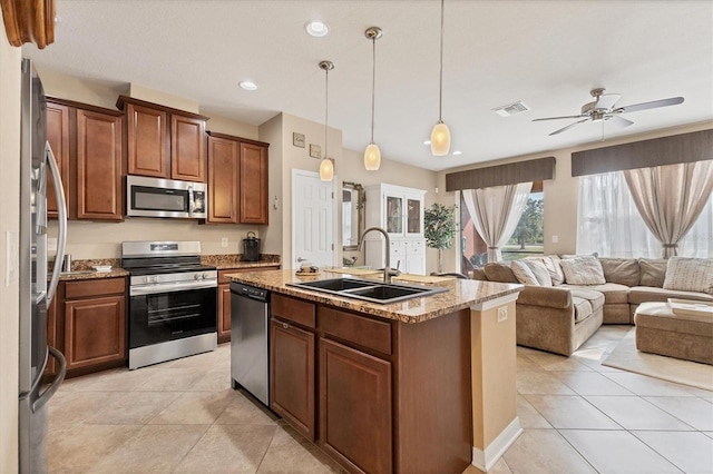 11507 84th Street Cir E Unit 102, Parrish, FL 34219 - kitchen featuring stainless steel appliances, a sink, light stone counters, open floor plan, and light tile patterned floors