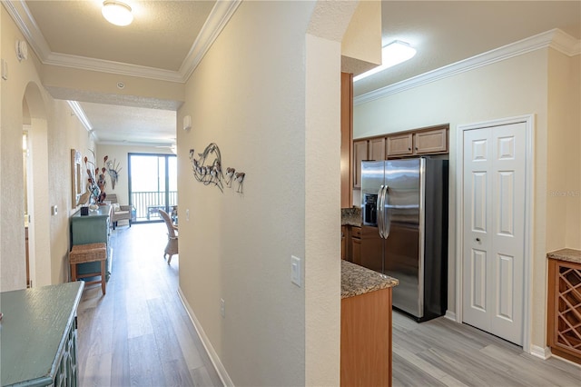 7005 River Hammock Dr Unit 204, Bradenton, FL 34212 - hallway featuring arched walkways, light wood-style flooring, crown molding, and baseboards