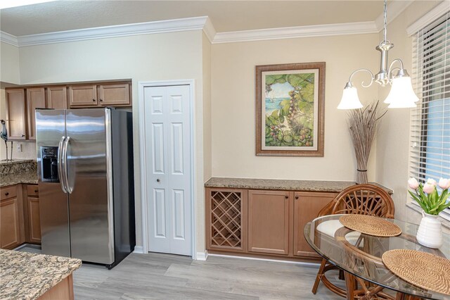 7005 River Hammock Dr Unit 204, Bradenton, FL 34212 - kitchen featuring stainless steel refrigerator with ice dispenser, ornamental molding, light stone countertops, light wood-style floors, and brown cabinetry