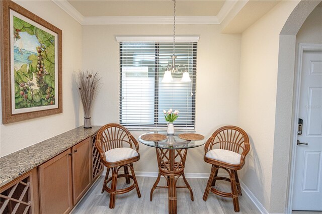 7005 River Hammock Dr Unit 204, Bradenton, FL 34212 - dining area with light wood-style floors, arched walkways, crown molding, baseboards, and a chandelier