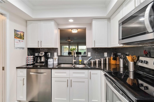 6999 W Country Club Dr N Unit 224, Sarasota, FL 34243 - kitchen featuring appliances with stainless steel finishes, a sink, decorative backsplash, dark countertops, and crown molding