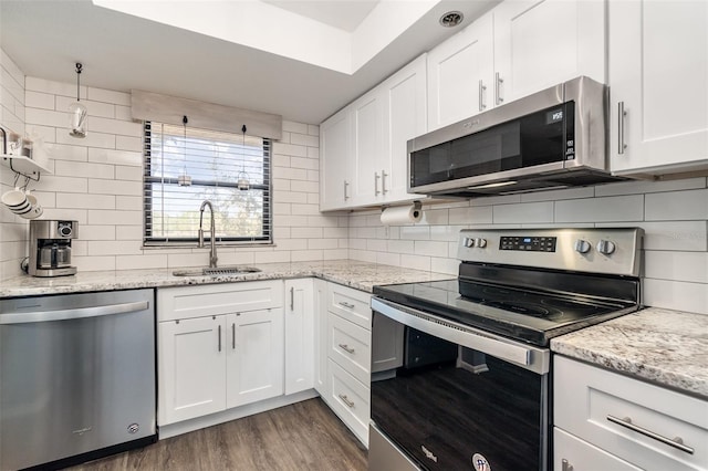 104 Capri Isles Blvd Unit 207, Venice, FL 34292 - kitchen featuring appliances with stainless steel finishes, a sink, decorative backsplash, white cabinets, and dark wood-type flooring