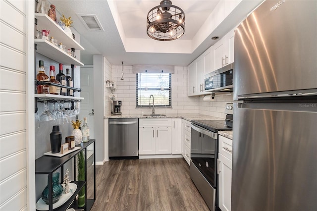 104 Capri Isles Blvd Unit 207, Venice, FL 34292 - kitchen featuring stainless steel appliances, a sink, decorative backsplash, white cabinetry, and dark wood-style flooring