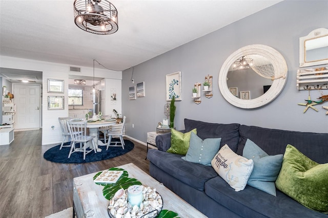 104 Capri Isles Blvd Unit 207, Venice, FL 34292 - living room with wood finished floors, baseboards, and a chandelier