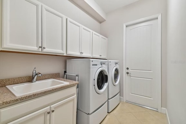 311 Compass Point Dr Unit 101, Bradenton, FL 34209 - laundry area featuring separate washer and dryer, cabinet space, light tile patterned floors, and baseboards