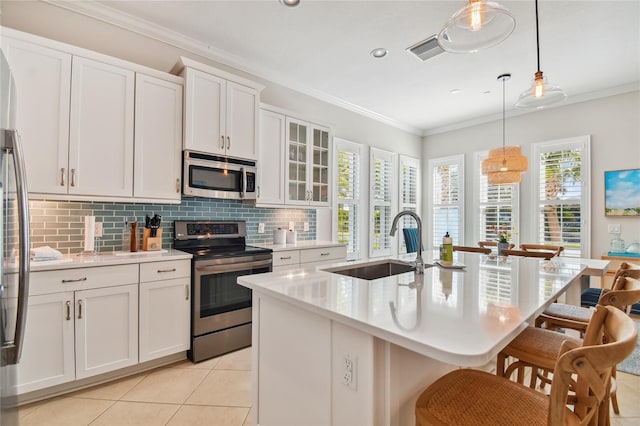 311 Compass Point Dr Unit 101, Bradenton, FL 34209 - kitchen featuring stainless steel appliances, a sink, a breakfast bar, backsplash, and light tile patterned floors