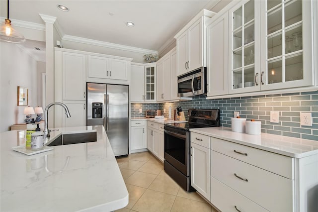 311 Compass Point Dr Unit 101, Bradenton, FL 34209 - kitchen with appliances with stainless steel finishes, a sink, crown molding, backsplash, and light tile patterned floors
