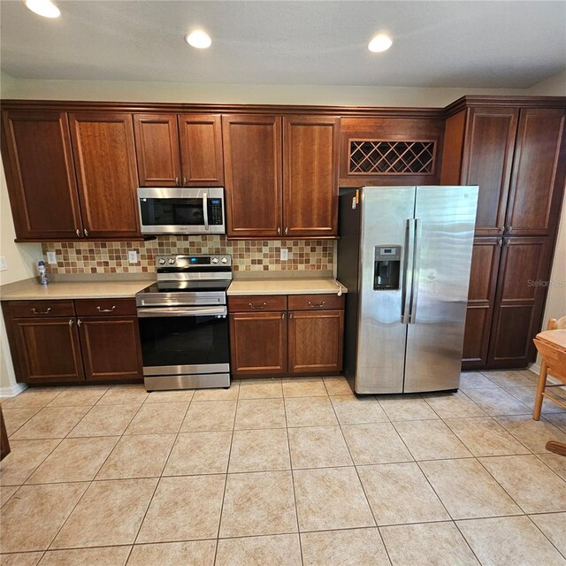 8110 Villa Grande Ct, Sarasota, FL 34243 - kitchen featuring stainless steel appliances, light countertops, backsplash, light tile patterned floors, and recessed lighting