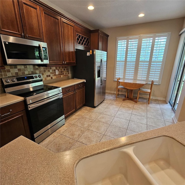 8110 Villa Grande Ct, Sarasota, FL 34243 - kitchen featuring stainless steel appliances, light countertops, decorative backsplash, recessed lighting, and baseboards