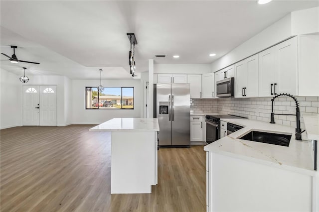3239 Daytona Dr, Punta Gorda, FL 33983 - kitchen with stainless steel appliances, a sink, ceiling fan, backsplash, and light wood-type flooring