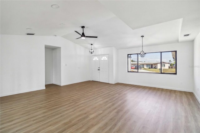 3239 Daytona Dr, Punta Gorda, FL 33983 - unfurnished living room featuring wood finished floors, a chandelier, baseboards, vaulted ceiling, and a ceiling fan