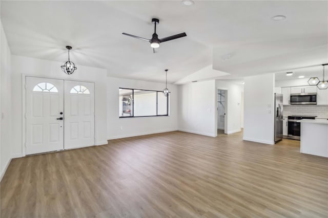 3239 Daytona Dr, Punta Gorda, FL 33983 - unfurnished living room featuring light wood-type flooring, baseboards, a ceiling fan, recessed lighting, and vaulted ceiling