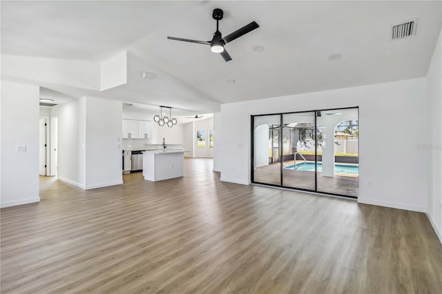 3239 Daytona Dr, Punta Gorda, FL 33983 - unfurnished living room featuring ceiling fan, high vaulted ceiling, light wood finished floors, and baseboards