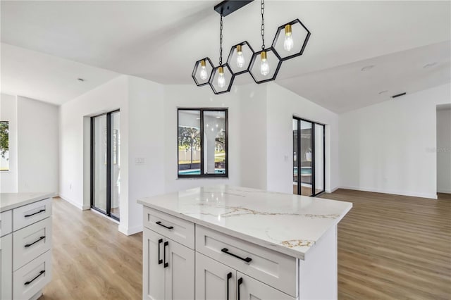3239 Daytona Dr, Punta Gorda, FL 33983 - kitchen with light wood-style floors, a center island, open floor plan, baseboards, and white cabinetry