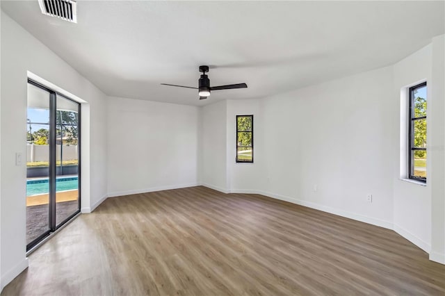3239 Daytona Dr, Punta Gorda, FL 33983 - unfurnished room with wood finished floors, healthy amount of natural light, ceiling fan, and baseboards