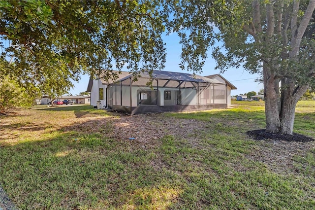 3239 Daytona Dr, Punta Gorda, FL 33983 - back of house featuring a lawn, glass enclosure, and stucco siding