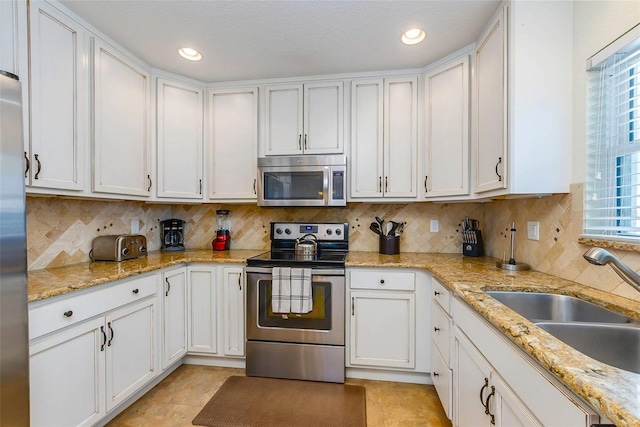112 Palm Ave, Anna Maria, FL 34216 - kitchen featuring appliances with stainless steel finishes, a sink, white cabinets, backsplash, and recessed lighting