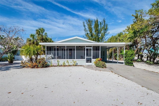 112 Palm Ave, Anna Maria, FL 34216 - rear view of house featuring a sunroom, ceiling fan, driveway, and a carport