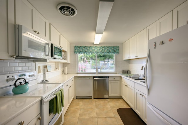 1350 N Portofino Dr Unit 208, Sarasota, FL 34242 - kitchen featuring stainless steel appliances, backsplash, white cabinetry, and a sink