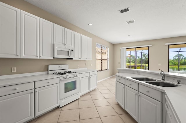 8118 Stirling Falls Cir, Sarasota, FL 34243 - kitchen with white appliances, light tile patterned flooring, light countertops, white cabinetry, and recessed lighting