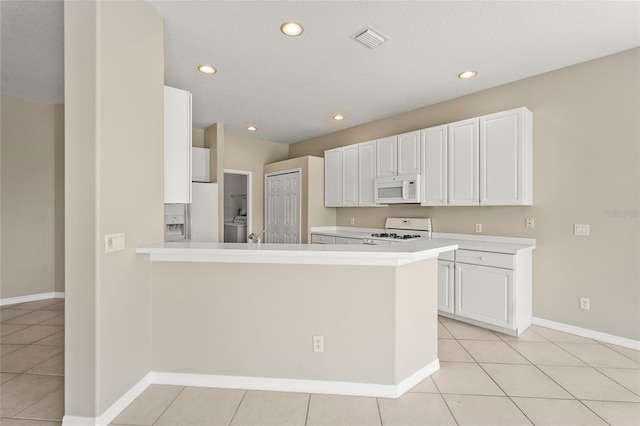 8118 Stirling Falls Cir, Sarasota, FL 34243 - kitchen featuring white appliances, light countertops, light tile patterned floors, recessed lighting, and white cabinets