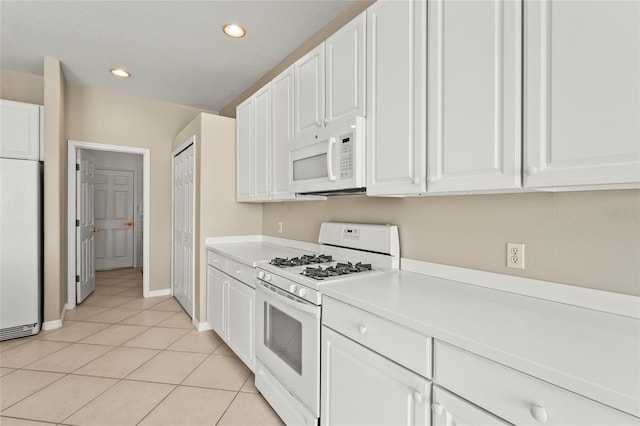 8118 Stirling Falls Cir, Sarasota, FL 34243 - kitchen with white appliances, white cabinetry, light countertops, light tile patterned flooring, and recessed lighting